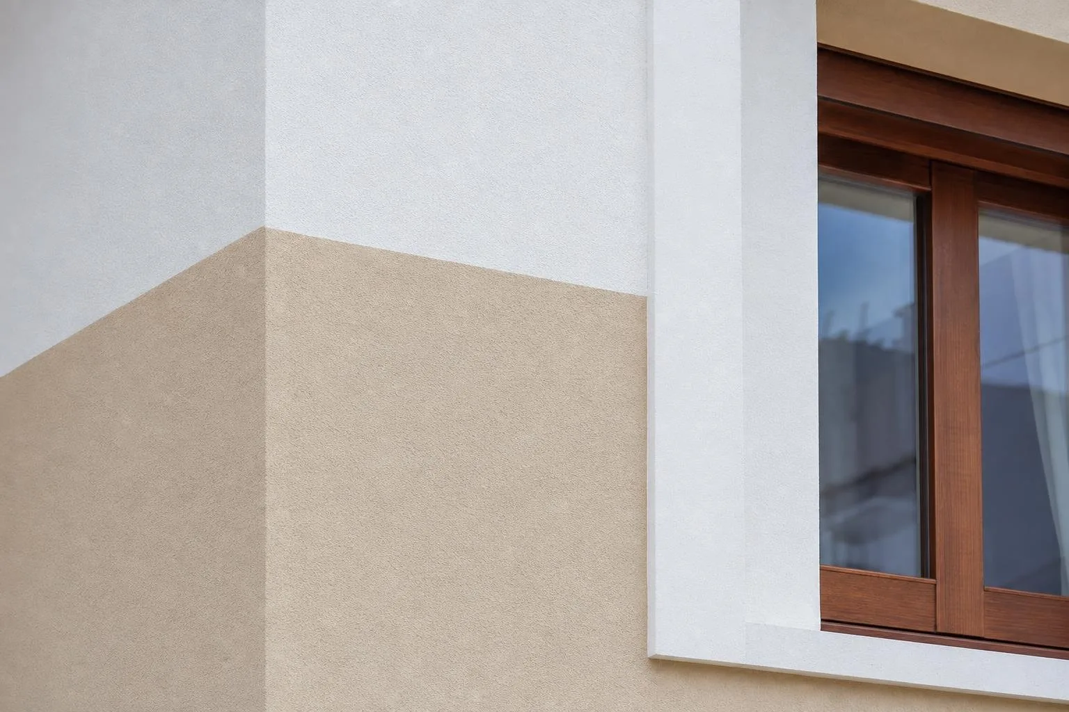 Detalle de fachada pintada con cortes limpios junto a una ventana