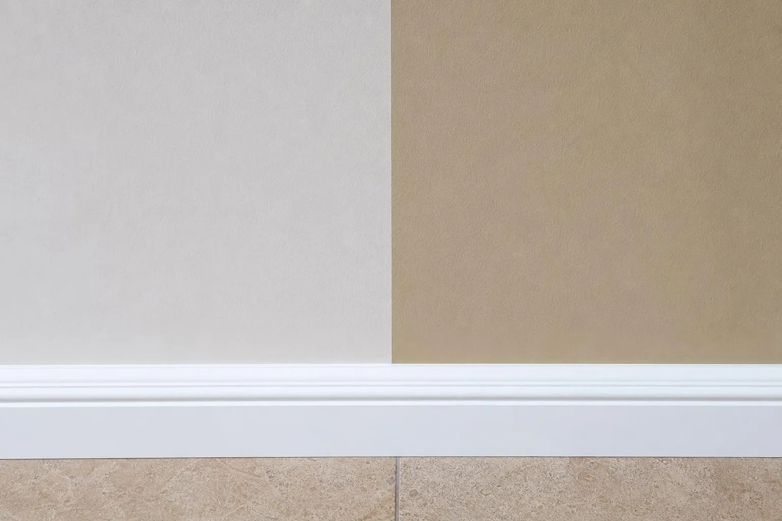 Detalle de una línea de pintura recta entre dos colores de pared