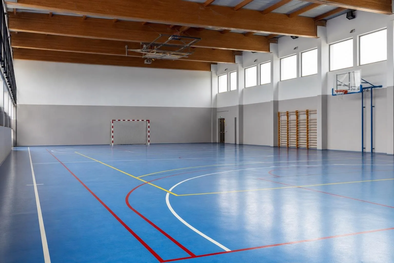 Pabellón deportivo cubierto con pavimento continuo y líneas pintadas